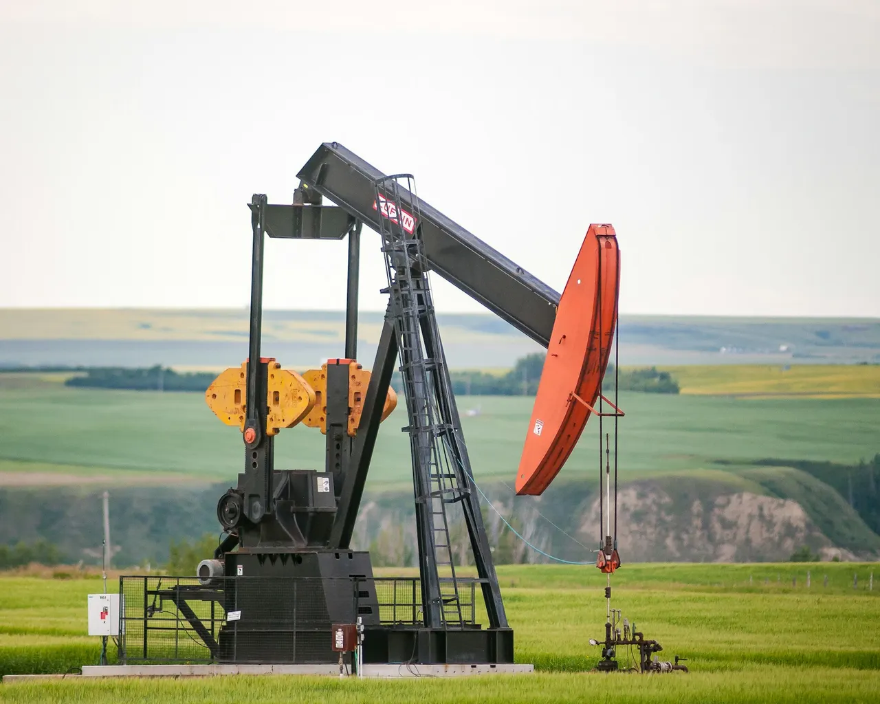 An oil well pump jack on green grassland
