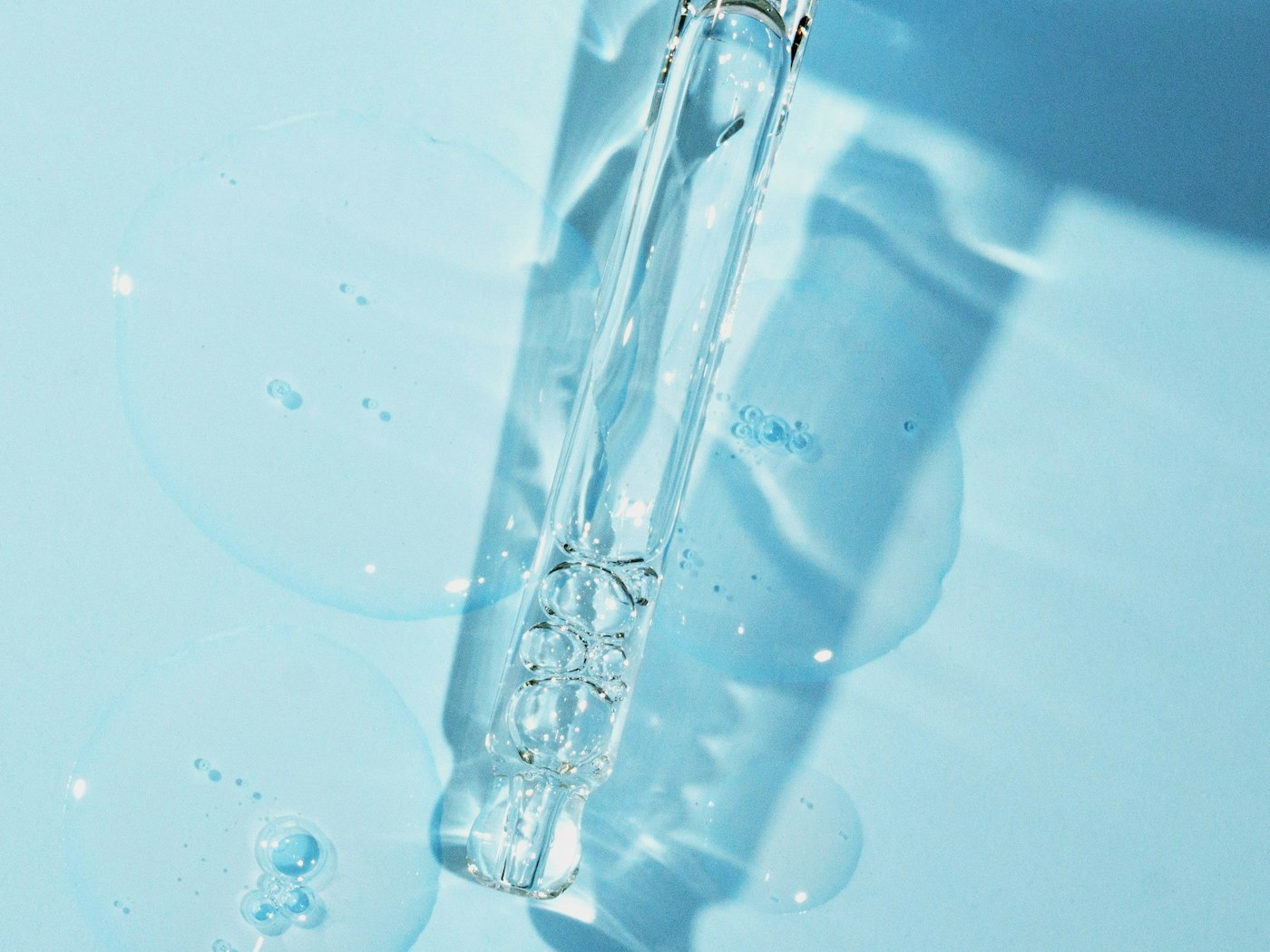 A pipette drawing up a clear blue liquid