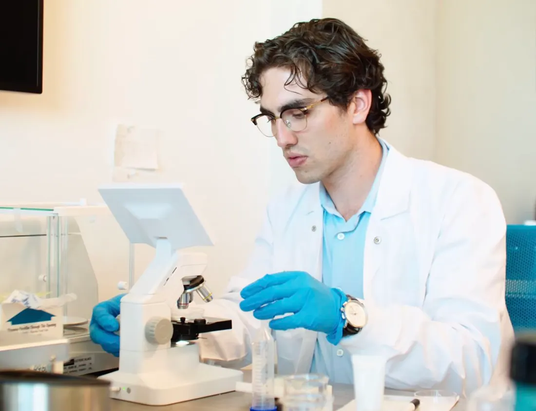 Sinan Gölhan, GelTech's founder and CEO, at the bench with a microscope